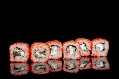 Philadelphia rulosu somon, peynir ve salatalık ile siyah arka planda yansımalı. Suşi Philadelphia.
