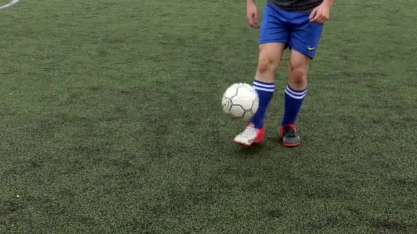 Украина, Киев - 19 декабря 2019 года: Футболист делает трюки, чтобы избежать защитника, дриблинг футбольный мяч на зеленой траве. — стоковое видео