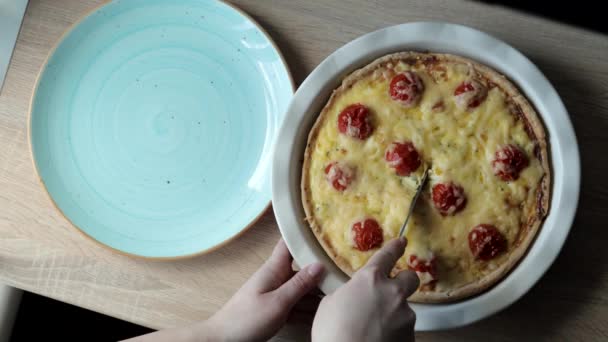 As mãos da mulher usando uma faca plana para separar a borda de uma quiche quente, recém-assado de sua lata de cozimento circular . — Vídeo de Stock