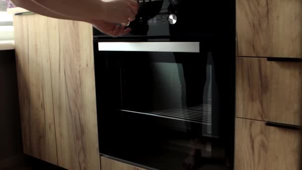 Femme allumant four vintage dans la cuisine, gros plan 