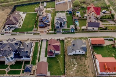 Asfaltlı, yeşil çimenli çimenli, beton zeminli bir evin havadan görünüşü.