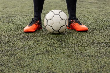 Futbol sahasında ayakları olan bir futbol topu.