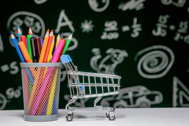 Kitap, kalem ve küre ile okul arka planına yeşil karatahta arka planında beyaz masa üzerinde