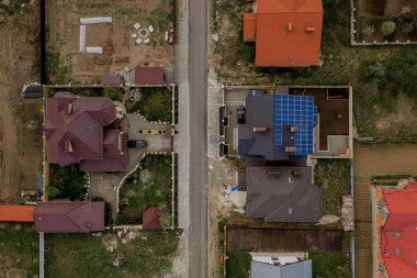 Mavi panelli, yeni, modern bir ev kulübesinin havadan görünüşü. Yenilenebilir ekolojik yeşil enerji üretim kavramı.