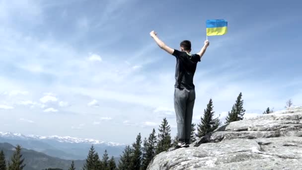 Man Stands Holding Ukraine Flag Waving Slow Motion Bright Overlook — Stock Video