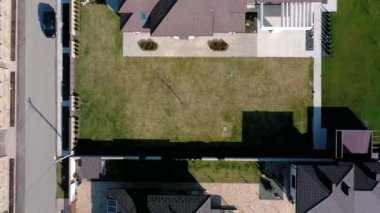 Beton zeminli yeşil çimenli asfalt bahçeli özel bir evin havadan görünüşü