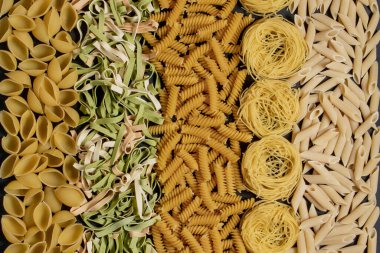 Kuru İtalyan makarnasının çeşitli çeşitleri ve şekilleri. İtalyan makarnası çiğ gıda arka planı veya dokusu: makarna, spagetti, spiral şeklinde makarna