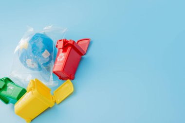 Sarı, yeşil ve kırmızı geri dönüşüm kutularında mavi arka planda geri dönüşüm sembolü var. Şehri düzenli tutar, geri dönüşüm sembolünü bırakır. Doğa koruma kavramı.