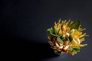 Spagetti macunu ve koyu arka planda yemek pişirmek için diğer ürünler. Metin için boşluk, üst görünüm.