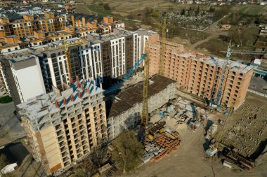 Yüksek binaların inşaatı ve inşaatı, çalışma ekipmanları ve işçileri olan inşaat endüstrisi. Yukarıdan bak, yukarıdan. Arkaplan ve doku.