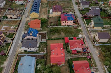 Asfaltlı, yeşil çimenli çimenli, beton zeminli bir evin havadan görünüşü.