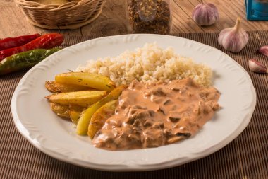 Vejetaryen mantar straganof pirinç ve rustik patates ile.