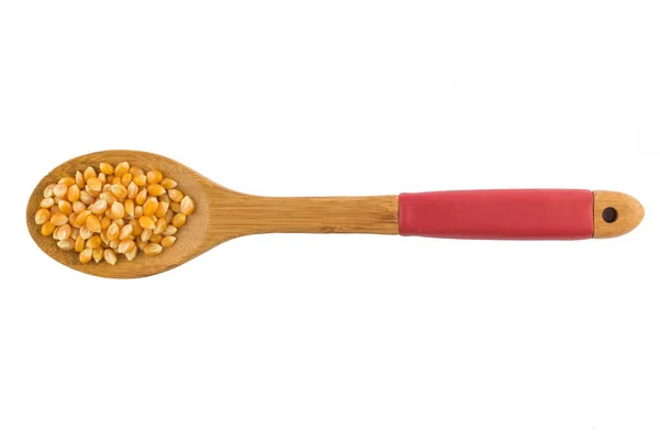 Palomitas de maíz. Grano crudo en una cuchara — Foto de Stock