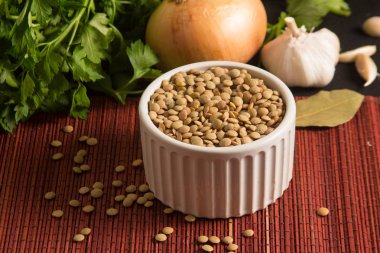 Ahşap bir masa üzerinde bir kapta çiğ mercimek