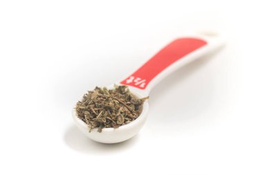 Kurutulmuş Oregano, beyaz arka planda çay kaşığı haline getirildi.