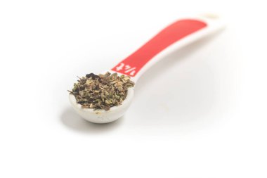 Kurutulmuş Oregano, beyaz arka planda çay kaşığı haline getirildi.