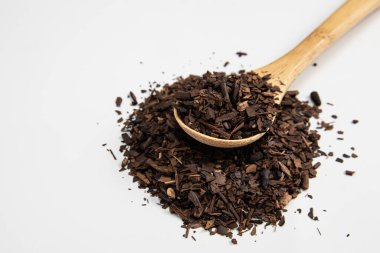 Kızarmış Erva-Mate beyaz arka planda bir ölçüm kaşığı haline getirildi