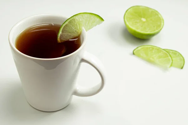 Cup of toasted Erva-Mate Tea with lemon on white background