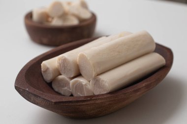 Beyaz arka planda bir kasede kesilmiş palmiye kalbi.