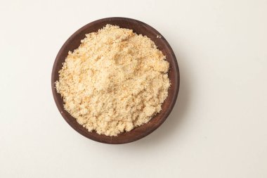 Brezilyalı Farofa. Manioc unu beyaz arka planda tahta bir kaseye konur.