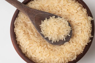 Parbolizado Rice beyaz arka planda bir kaseye konur. Kavrulmuş
