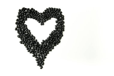Çiğ Brezilya Black Beans yığını. 'Feijao' olarak da bilinen kalp şekli beyaz arkaplanda izole edilmiştir.