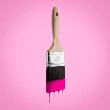 Boya fırçası pembe renkli kıllar, pembe bir arka plan üzerinde kapalı damlama ile yüklü.