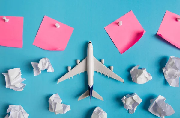 Modelo de avião voando entre nuvens de papel e papel rosa anotado, conceito de viagem — Fotografia de Stock