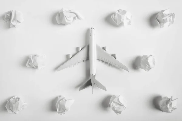 Flyg modell flyger bland papper moln, resor koncept, på vit bakgrund. — Stockfoto