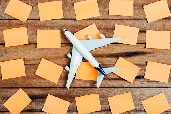 Förberedelse för resande koncept och att göra-lista, papperet noterade, flygplan, på en vintage trä bakgrund med kopia utrymme. — Stockfoto