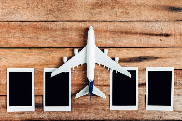 Förberedelse för resande koncept, flygplan med fotoram, på en vintage trä bakgrund med kopia utrymme. — Stockfoto
