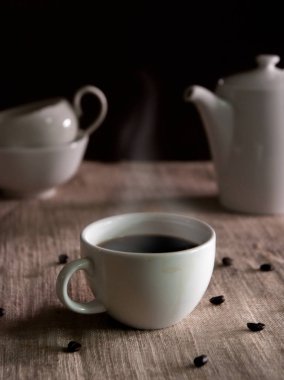 bir fincan kahve fasulye yumuşak odak antika arka plan etrafında sıcak duman ile sıcak.