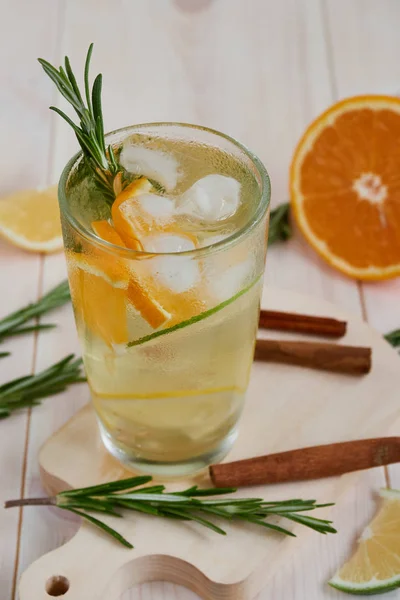 Refreshing Summer Cocktail with Citrus Fruits and rosemary on a Wooden Table