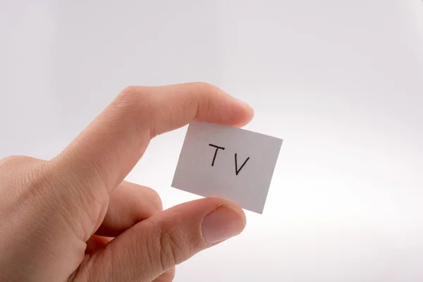 TV written little white paper in hand — Stock Photo, Image