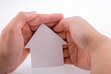 Bir kağıt ev tutan el