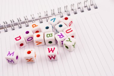 Harf küpleri alfabesinin çeşitli renk üstünde bir spiral defter