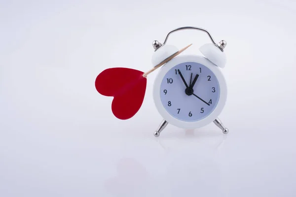 Reloj despertador de color blanco y forma de corazón rojo —  Fotos de Stock