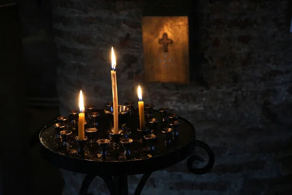 Sinal de cruz e e velas sobre fundo escuro — Fotografia de Stock