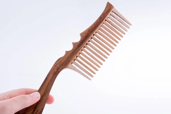 Hand holding a comb — Stock Photo, Image