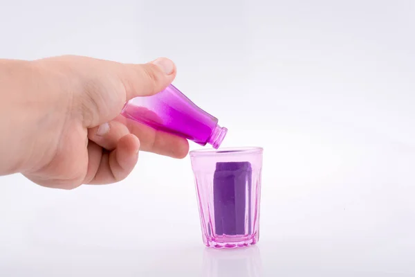 Pequeña botella colorida sobre un vaso —  Fotos de Stock
