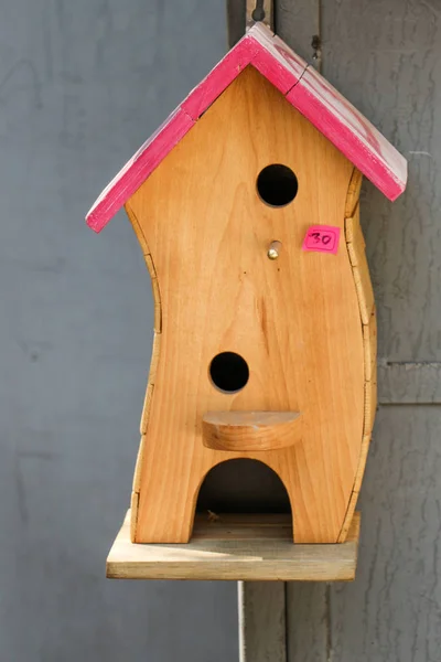 Деревянный птичий дом с отверстиями — стоковое фото