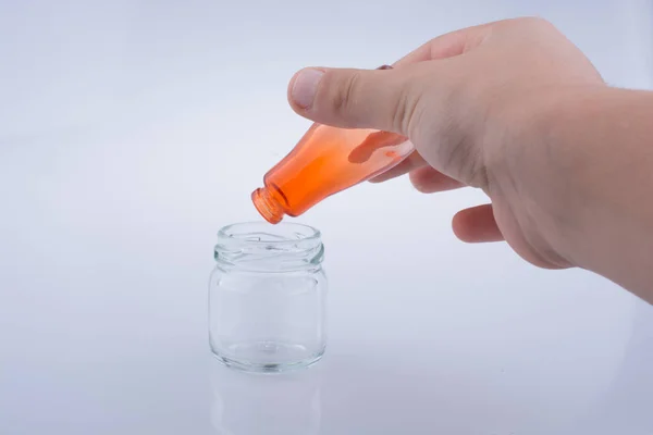 Pequeña botella colorida sobre un frasco —  Fotos de Stock