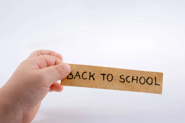 Mano bambino in possesso di un titolo di ritorno a scuola — Foto Stock