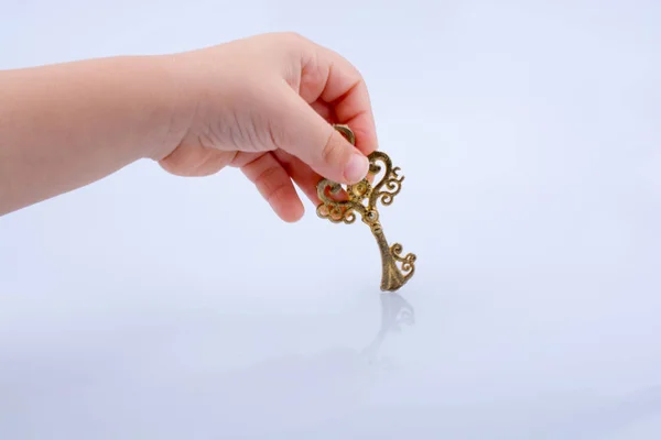 Παιδί χέρι κρατά ένα ρετρό στυλ κλειδί — Φωτογραφία Αρχείου