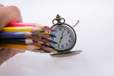 Renkli kalemler bir saat tutan el