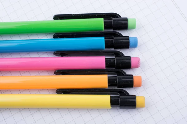 Механические карандаши различного цвета на ноутбуке — стоковое фото