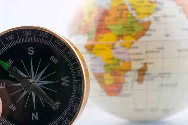 Globe by the side of a compass — Stock Photo, Image