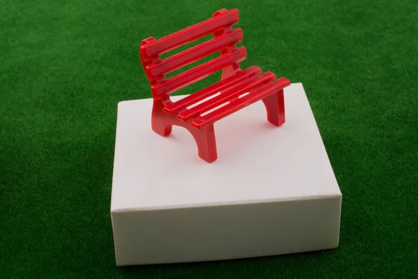 Pequeño banco rojo en miniatura hecho de plástico — Foto de Stock