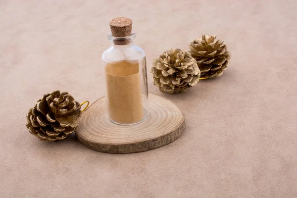 Pine cones and a bottle on a piece of cut wood