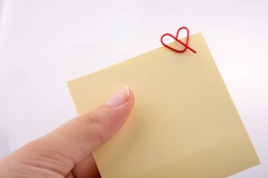 Kalp şeklinde küçük bir not kağıdına tutan el